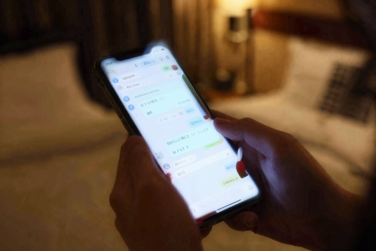 スマートフォンの画面に映るLINEメッセージ——テキストによる遠隔支配と報告義務のイメージイラスト